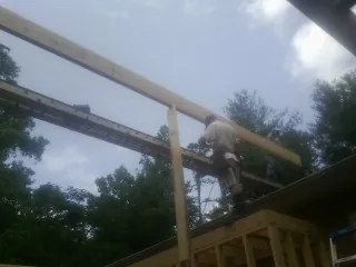 Carpenter setting a ridge beam over a new addition frame — Ice Dam Removal by Roofing Brothers in Chippewa Lake